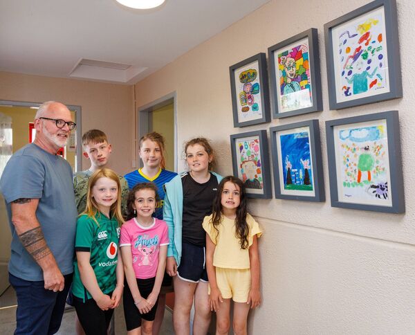 Martin with pupils Joey Doyle, Cormac Phelan, Kaitlynn Dermody, Grace Carroll, Amelia Walsh and Megan Dermody beside their artwork with Mr. Duffy as the theme