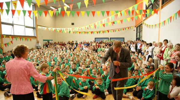 Mícheál Ó Muircheartaigh cutting the ribbon to officially open the Gaelscoil's new permanent building in 2007