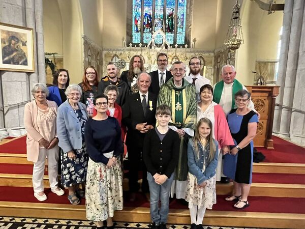 Jim Carthy with Bishop Denis Nulty, Fr John Dunphy and his family as he receives the Benemerenti Medal in St Clare's Church, Graiguecullen