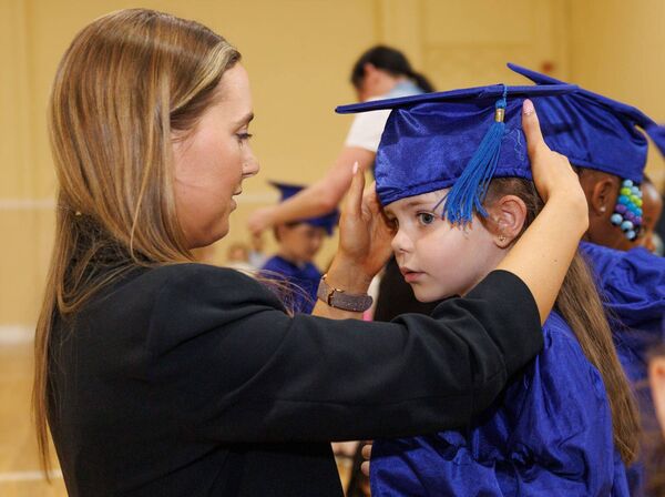 Teacher Jodie Regan helps Rebecca with her cap during the Graiguecullen Parish Childcare Centre's preschool graduation in St Fiacc's Hall in Graiguecullen Photos: michaelorourkephotography.ie Teacher Jodie Regan helps Rebecca with her cap during the Graiguecullen Parish Childcare Centre's preschool graduation in St Fiacc's Hall in Graiguecullen Photos: michaelorourkephotography.ie