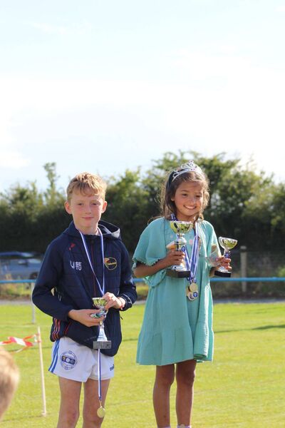 Cathal Connolly Moran and Maysa Lopes de Magalhaes receiving their medals and trophies for some of the family events at the Grange Community Walkathon and family fun day 