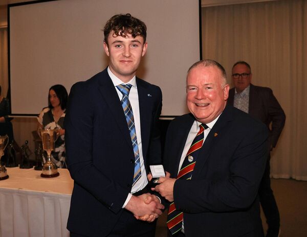 Darragh Byrne receives his medal from Carlow GAA Chairman Jim Bolger.