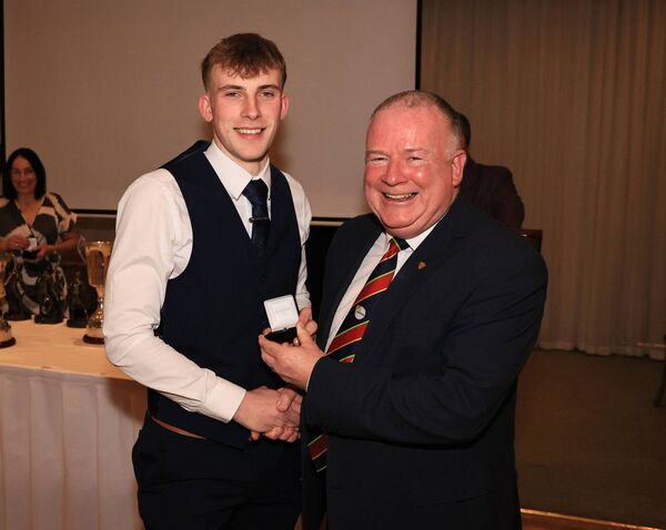 Lorcan Doyle receives his county Junior Championship medal from Jim Bolger