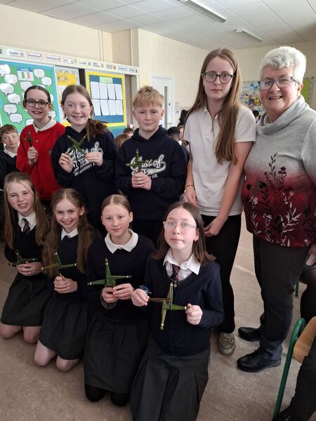 Pupils from Bennekerry NS show their St Brigid's Day crosses to Catherine Nolan