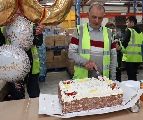John Cummins cuts a cake to celebrate 50 years of working in Torc Candles, Borris 