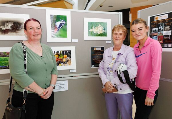 Margaret Walsh shows her photographs to her daughter Marie Walsh and granddaughter Molly Hickey