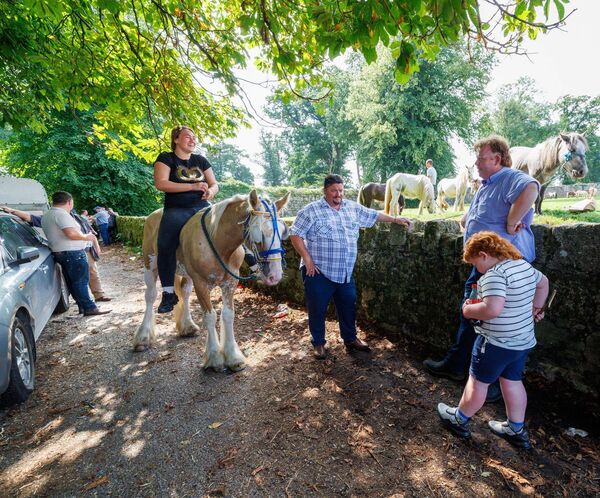 Lively conversations and laughter at the Borris Fair, as a young rider sits proudly on her horse
