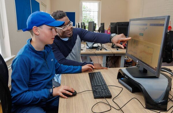 Professor Emmanuel Darkwa helps Samuel Bayley during the Digital Skills Summer Camp in Carlow College