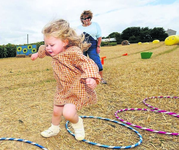 Esther Dagg looks on as her granddaughter Isabelle amuses herself at the sunflowers