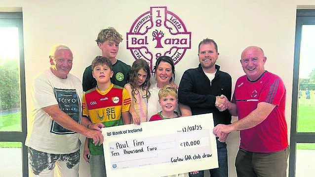 <p>Paul Finn, winner of the top prize of €10,000 in the Carlow GAA bounty board draw, pictured with his family receiving the cheque from Ballon GFC officials John Kelly and Billy Fanning</p>