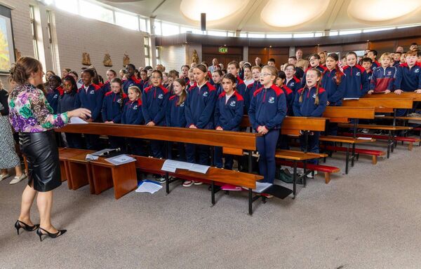 The choir directed by teacher Lisa Dooley sing the school anthem for the first time