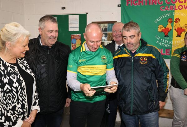 Jim Gavin receives a club history from The Fighting Cocks GAA Club with Minister of State Jennifer Murnane O'Connor, John McDonald, cllr John Pender and Cathal Shanahan, club chairman