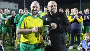 <p>Crettyard Utd captain Niall Purcell receiving the Senior Div 1 cup from Bernard Mullen</p>