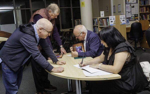 John MacKenna and Faye Tucker sign copies of the book for Jim Fitzharris and Dermot O'Leary