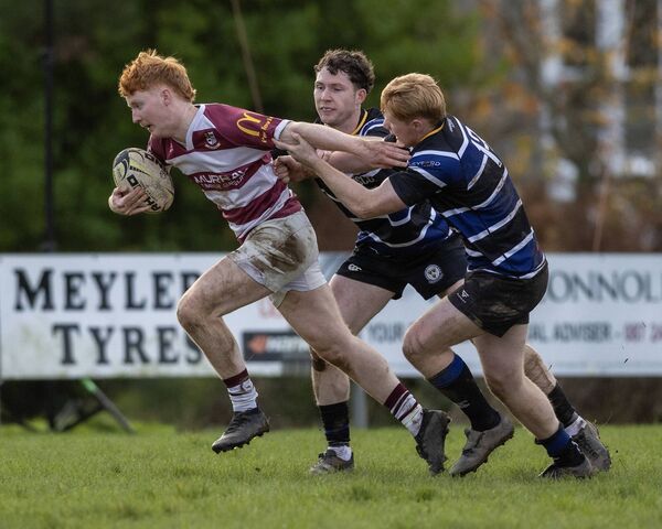 Tullow's Dara Cosgrave battles to get away from Wexford's Shane McGuinness and Mark Power.