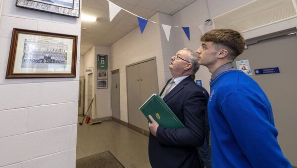 Knockbeg College head prefect Énnae Byrne shows minister of state Michael Moynihan the jersey and picture of the college's team that won the 2005 All-Ireland Post-Primary A championship Photos: Michael O'Rourke Photography