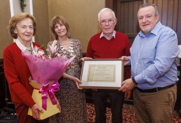 Martin Nevin is presented with a certificate of appreciation by John Kelly (editor) and Helen Doyle. Martin's wife Rosaleen was presented with a bouquet of flowers