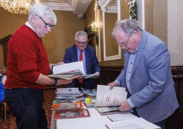 Paul Curran, Richard Codd and Padraig Dooley from the CHAS committee look through old issues of 'Carloviana'
