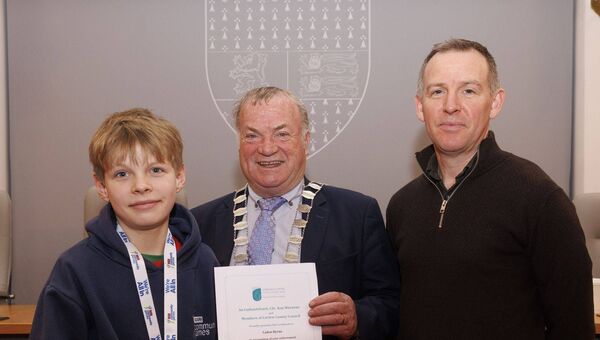 Cllr Ken Murnane presents Caden Byrne, a gold medalist in the U12 cycling on grass event. Also shown is his father, Adam