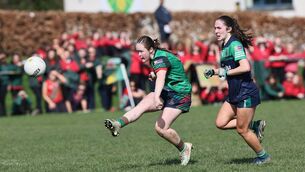 <p>Amy Wall watches her kick sail over the bar for a point for St Leo's	Photos: Pat Ahern</p>