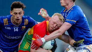 <p>Carlow's Conor Doyle is tackled by Ronan Sweeney and Joseph Hagan of Longford Photo: ©INPHO/Nick Elliott</p>