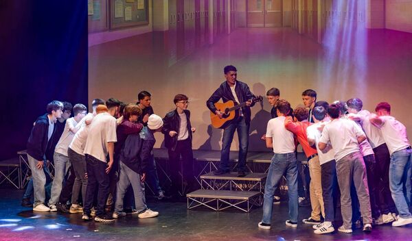 Rafael Rengi as Doody on stage with cast members 