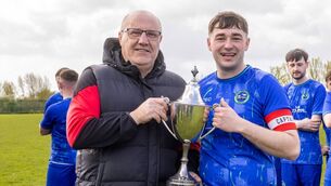 <p>Bernard Mullen (vice chairman CDFL) presents the Tully's Travel Division 1 Cup to Slaney Rovers captain Eoin Curran. </p>