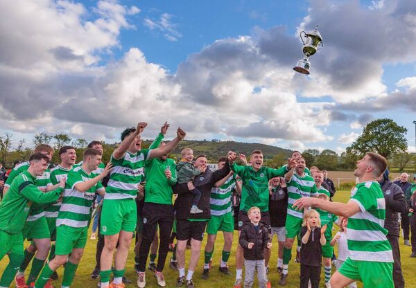 New Oak launch the cup in the air as they celebrate the 15th trophy of the Gavin Dowling era.