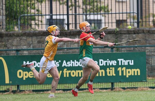 Carlow's Jake Nolan is chased down by Antrim's Niall Magee.