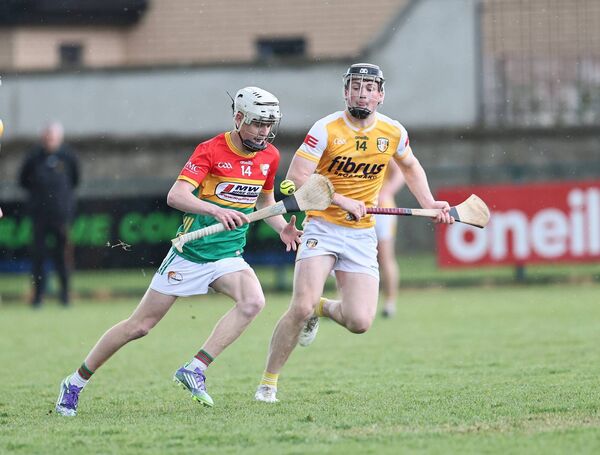 Carlow captain Kyle Nolan keeps his eye on the ball as he is chased by Antrim's Thomas McLaiughlin. All Photos: Pat Ahern.