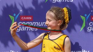 <p>Lucy Keogh of Myshall admires her u10 80m gold medal. </p>