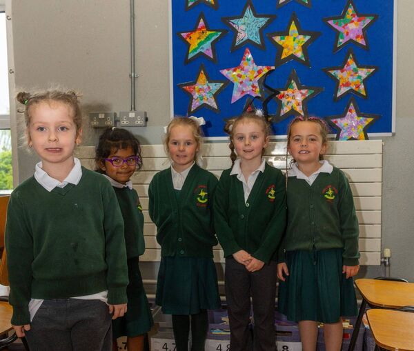 Junior infants stand proudly in front of their artwork Junior infants stand proudly in front of their artwork