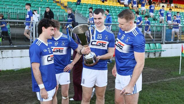 <p>Old Leighlin players admire the Nationalist Cup after winning last year's final, but who will be lifting it this year? Photo: Pat Ahern</p>