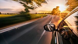 <p>Stock image of car driving on road</p>