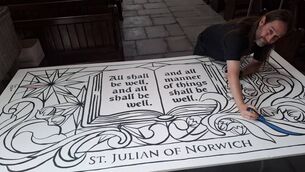 <p>Dean Máirt Hanley starts the colouring in of a mural in St Laserian's Cathedral</p>
