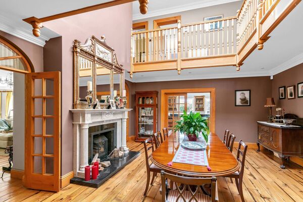 Dining Room with reclaimed pitch pine flooring. Double height ceiling with glass atrium roof light, overlooked by gallery landing. Two sets of double glass panel solid wood doors with arch window light to sitting room.