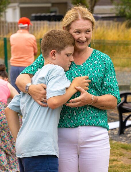 Sarah Halpin, treasurer of the committe, gets a hug from her son, Ryan, after she spoke during the official opening ceremony Sarah Halpin, treasurer of the committe, gets a hug from her son, Ryan, after she spoke during the official opening ceremony