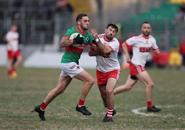 Clonmore's Shane McGrath pbarges past Éire Óg's Niall Swan. Photos: Pat Ahern.