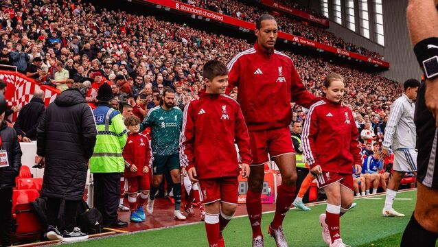 <p>Max Hutchinson, left, leading out the Liverpool team with captain Virgil van Dijk ahead of the premier league game against Nottingham Forest at Anfield on Saturday </p>