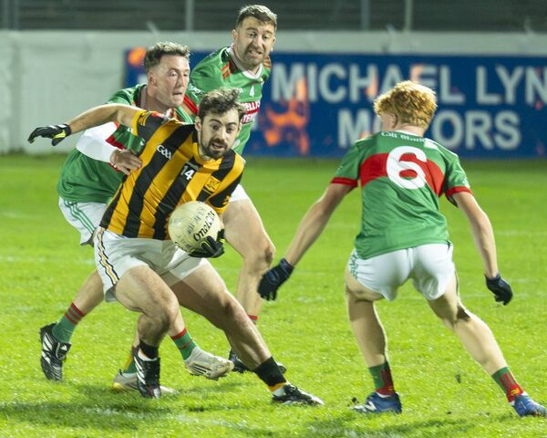 Naomh Eoin's James Smithers jinks around the Bzllon defence. 