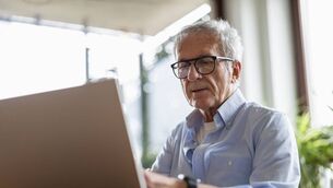 <p>Senior man using laptop at home. Image: iStock</p>