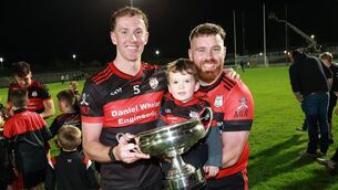 <p>Rangers players Kevin McDonald and Dean Grennan with the trophy and a potential star of the future.</p>