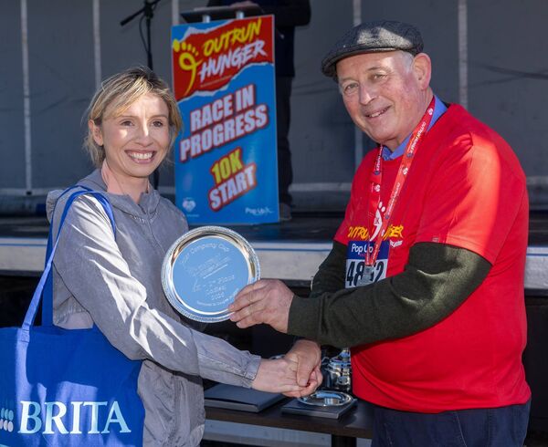Founder of St Clare's kitchen, Fr John Dunphy presents Leah Lawler with the prize for the first woman in the 5k race Founder of St Clare's kitchen, Fr John Dunphy presents Leah Lawler with the prize for the first woman in the 5k race
